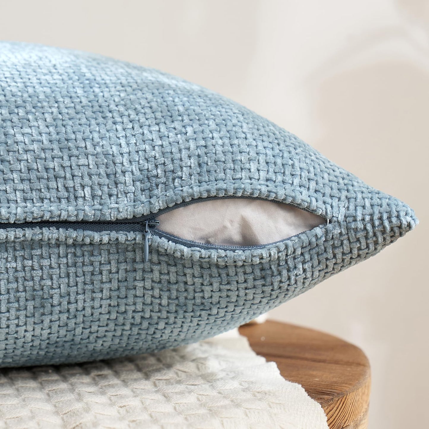 Textured 18x18 inch pillow covers in Storm Blue, Chambray, Steel, and Indigo showing a dense woven grid pattern, styled on a neutral sofa for coastal décor – Coastal Pillows Plus.