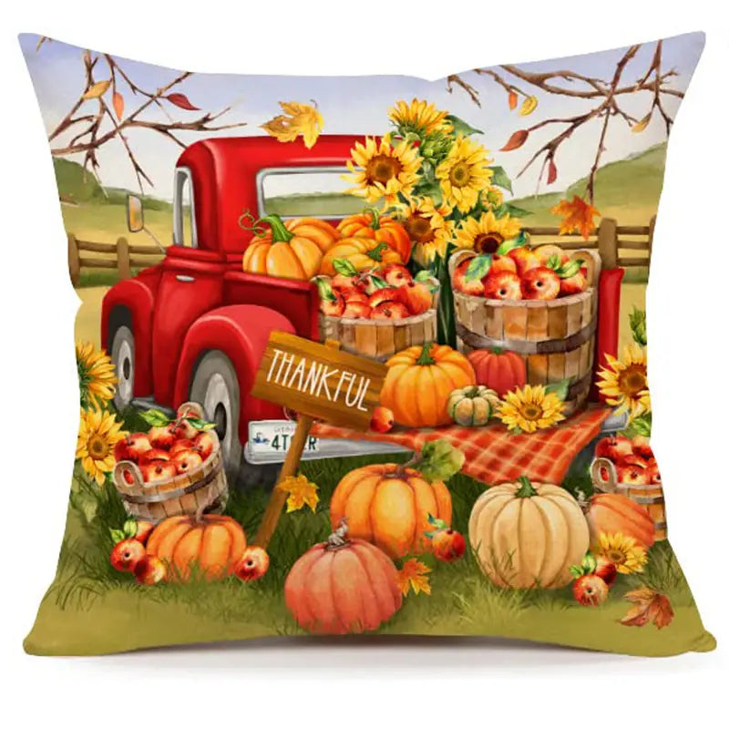 Pillow cover with red truck loaded with pumpkins and apples, sunflowers, and Thankful harvest sign.