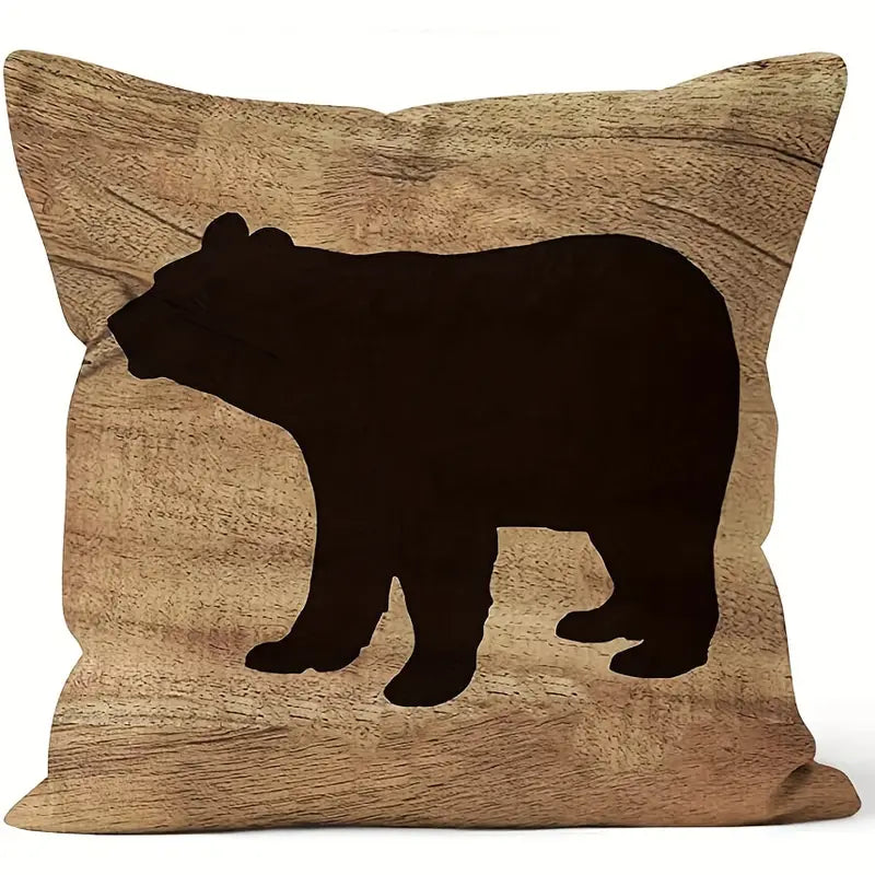 Square pillow cover featuring a dark bear silhouette against a warm wood-grain background.