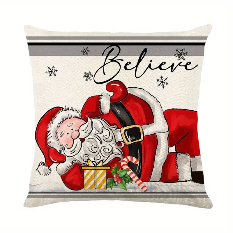 Decorative pillow cover featuring a whimsical illustration of Santa Claus resting in the snow with a gift and candy cane under the word "Believe" for holiday decor - 18x18.