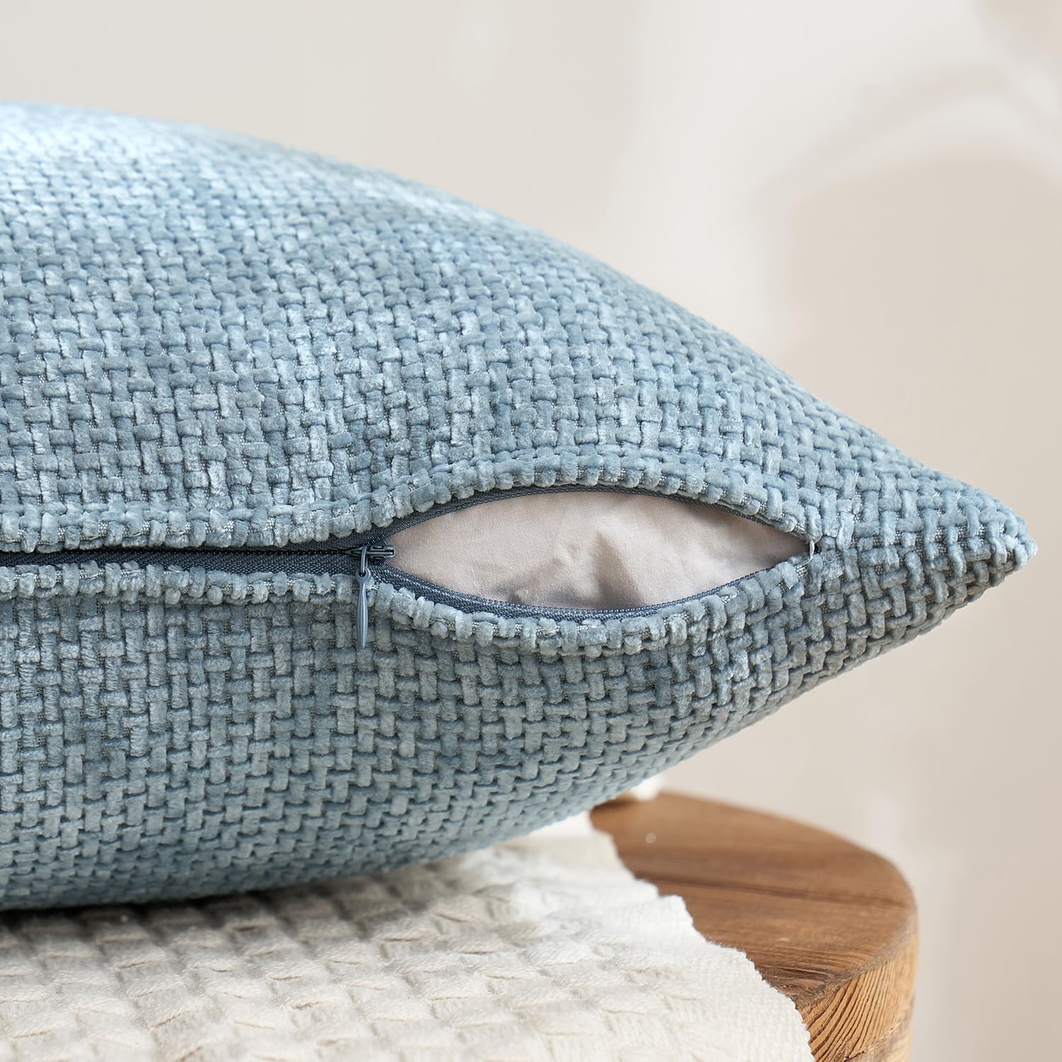 Textured 18x18 inch pillow covers in Storm Blue, Chambray, Steel, and Indigo showing a dense woven grid pattern, styled on a neutral sofa for coastal décor – Coastal Pillows Plus.