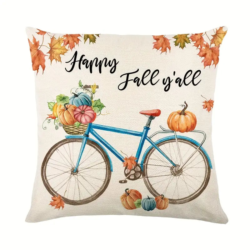 Linen pillow cover with Happy Fall Y’all text above blue bicycle carrying pumpkins and autumn leaves.