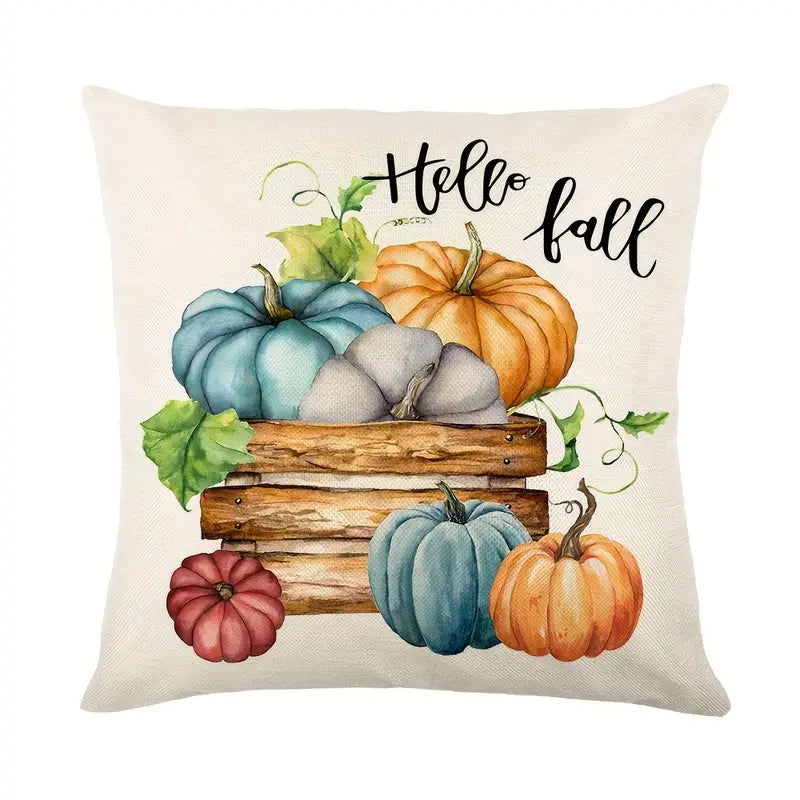 Linen pillow cover with Hello Fall text above wooden crate filled with orange and teal pumpkins.