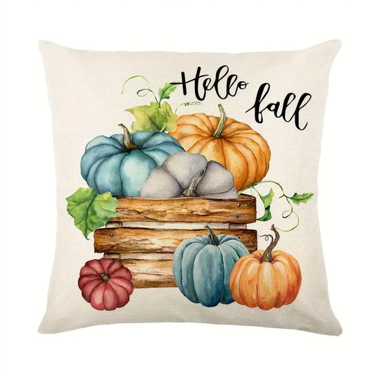 Linen pillow cover with Hello Fall text above wooden crate filled with orange and teal pumpkins.