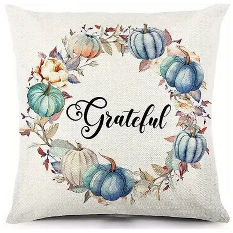 Pillow cover with Grateful text centered in wreath of teal and cream pumpkins and foliage.