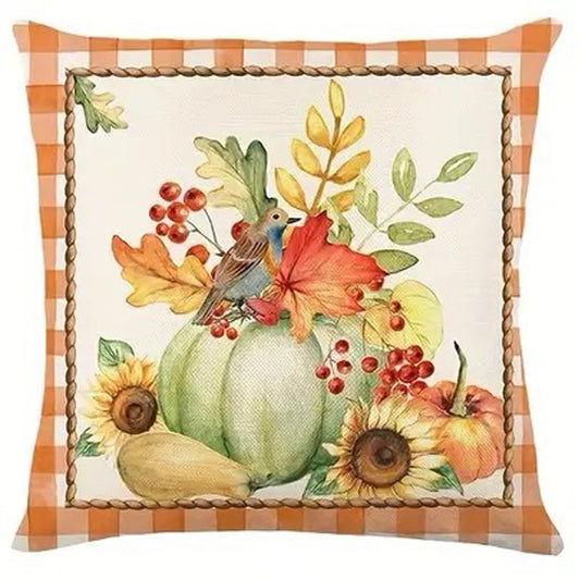 Pillow cover with green pumpkin, bird, sunflowers, red berries, and autumn leaves framed by orange gingham border.