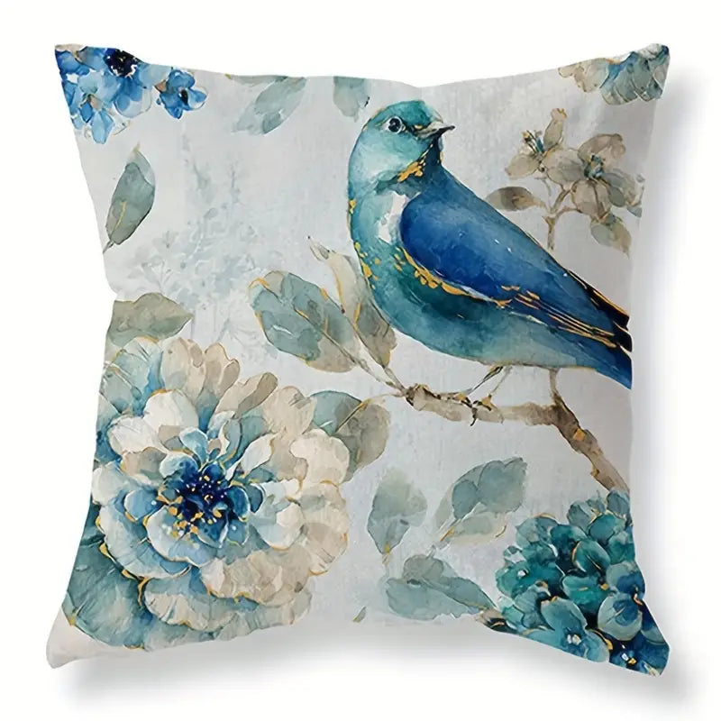 Decorative linen pillow cover featuring a blue bird perched among blue watercolor-style flowers on a light background.