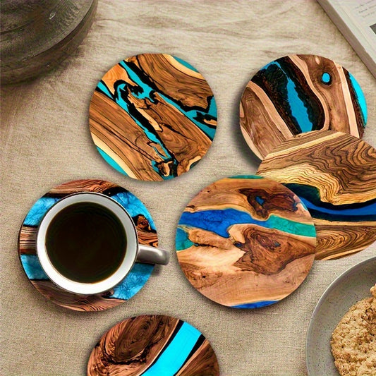 Round wood grain coasters with blue and green resin-style abstract designs on a table with a coffee cup.