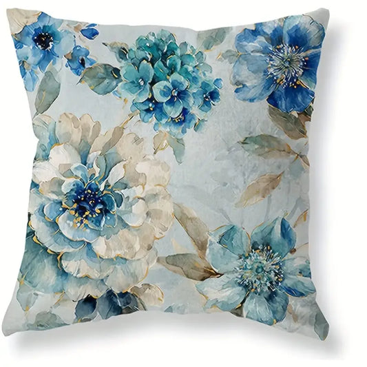 Decorative linen pillow cover featuring multiple blue watercolor-style flowers with soft neutral accents on a light background.