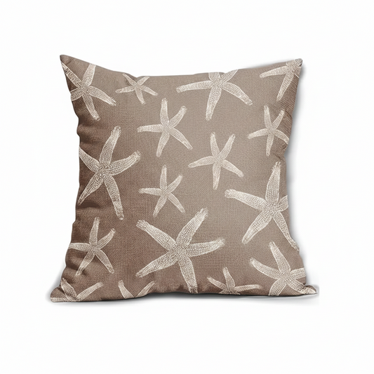 Brown pillow cover featuring a repeating ivory starfish pattern on woven fabric, styled on seating in a coastal-inspired setting.