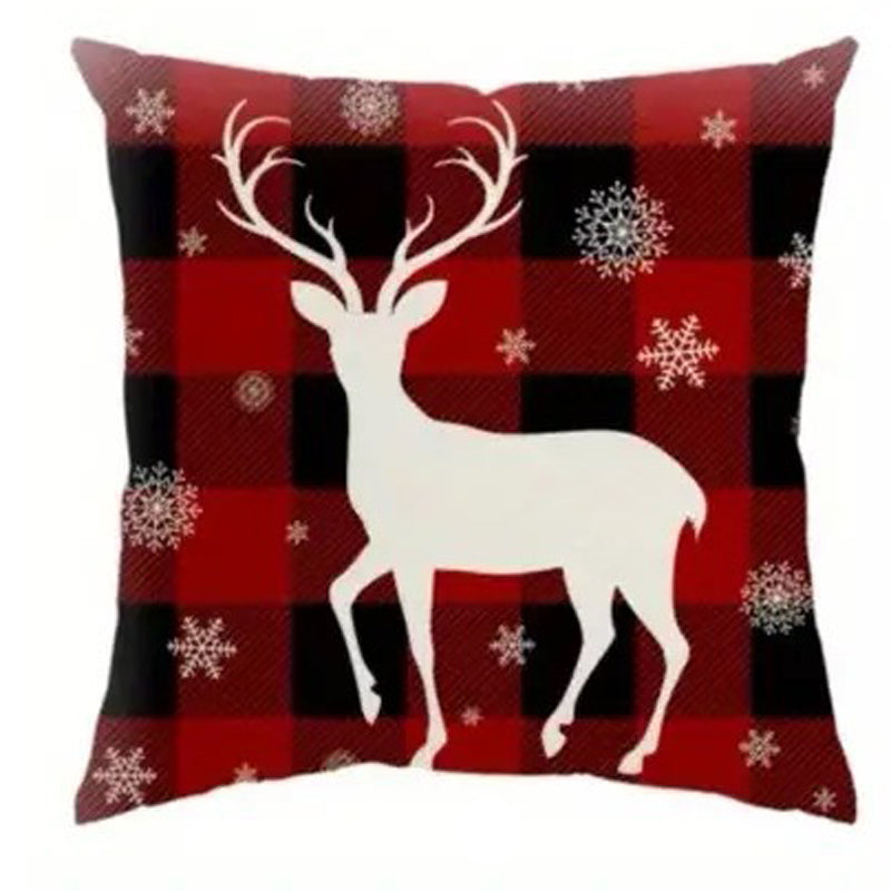 Buffalo plaid Christmas pillow cover featuring a white reindeer silhouette with snowflakes on a red and black plaid background.