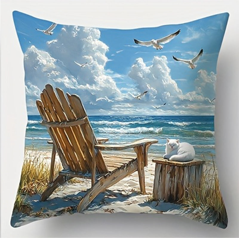 Coastal pillow cover featuring a wooden beach chair facing the ocean with a white cat on a nearby stool and seabirds in the sky.