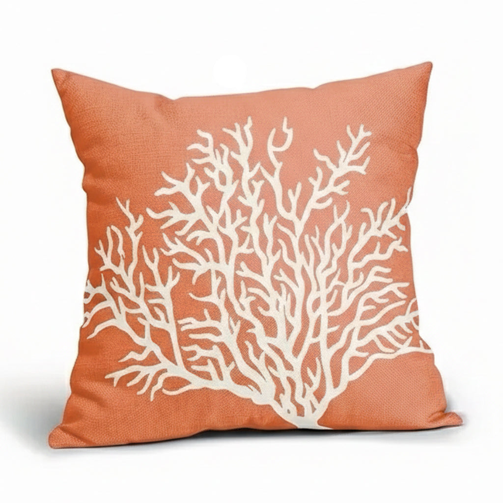 Coral-colored linen pillow cover featuring a white branching coral design on a textured fabric background.