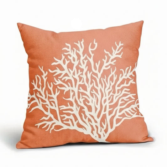 Coral-colored linen pillow cover featuring a white branching coral design on a textured fabric background.