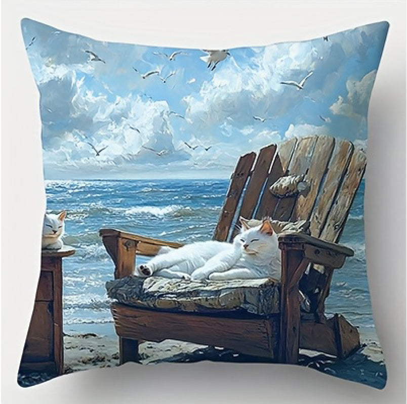 Coastal pillow cover featuring a white cat resting on a cushioned beach chair with ocean waves and flying seabirds in the background.