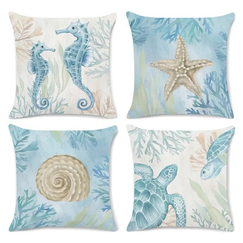 Four coastal pillow covers featuring watercolor-style seahorses, starfish, seashell, and sea turtle illustrations in soft blue and neutral tones.