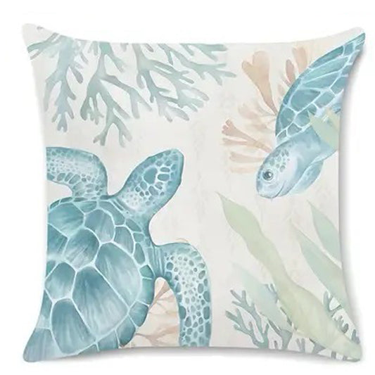 Coastal pillow cover featuring an illustrated sea turtle swimming among coral and sea plants in soft blue tones.