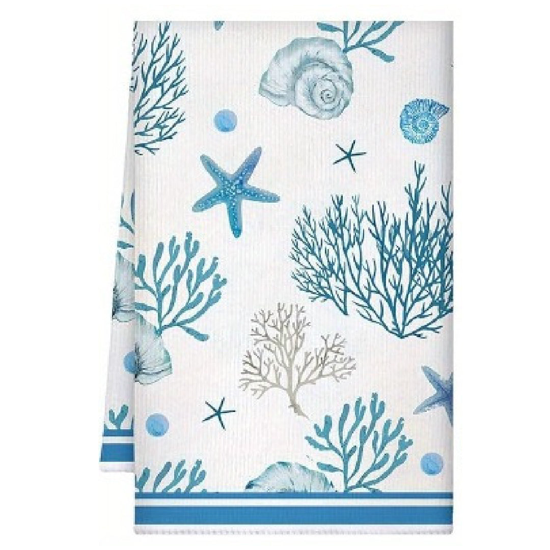 Towel with blue coral, starfish, and shell pattern on a white background