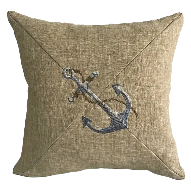 Neutral pillow cover with embroidered anchor design centered on textured fabric for coastal and nautical home decor.
