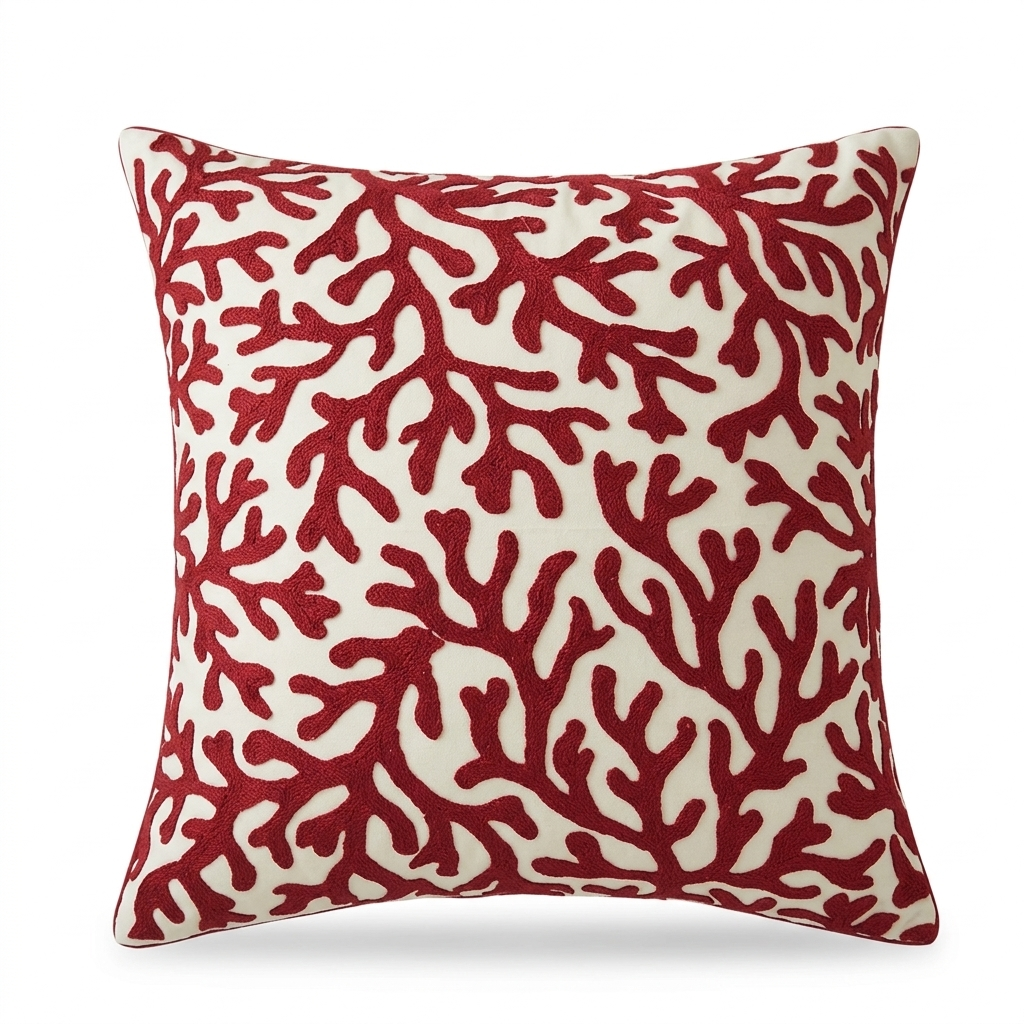 Coastal pillow cover with embroidered red coral pattern on a light fabric background for beach house and coastal home decor.