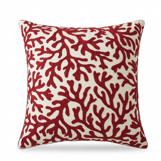 Coastal pillow cover with embroidered red coral pattern on a light fabric background for beach house and coastal home decor.