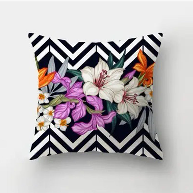 Decorative pillow cover featuring a central floral arrangement framed by a black and white chevron background.