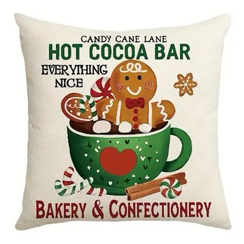 Christmas pillow cover featuring a gingerbread man sitting in a hot cocoa mug with candy canes and holiday sweets.