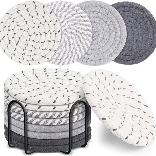 Round gray woven rope coasters stacked in a black metal holder with mixed light and dark gray tones.