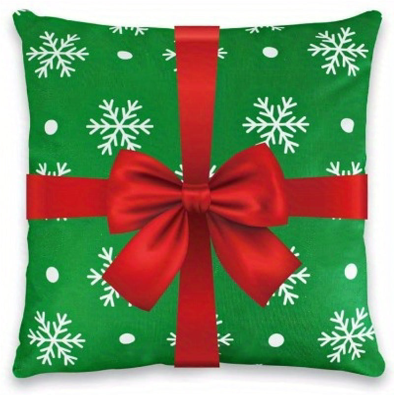 Green pillow cover with snowflakes and a red ribbon bow across the front