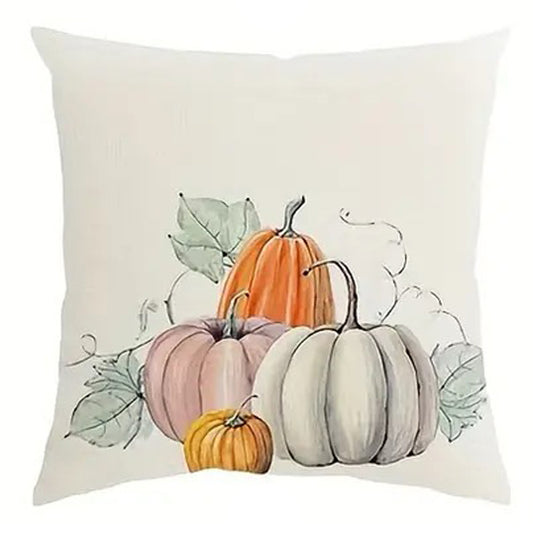 Linen pillow cover featuring a cluster of pumpkins in soft orange, white, and green with light foliage accents.