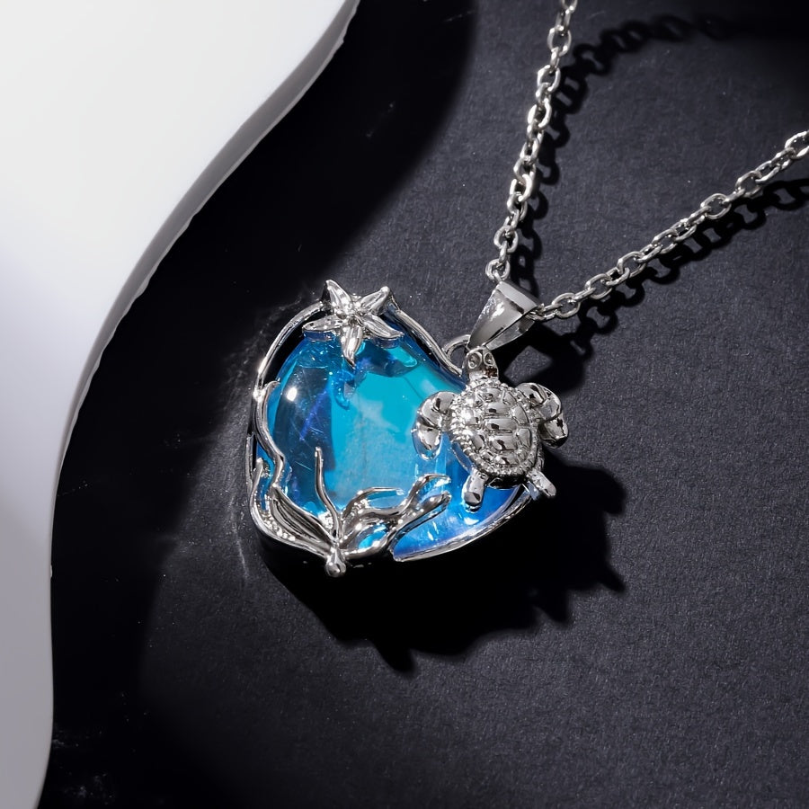 Silver turtle and starfish motif on a heart-shaped blue glass pendant necklace - Coastal Pillows Plus