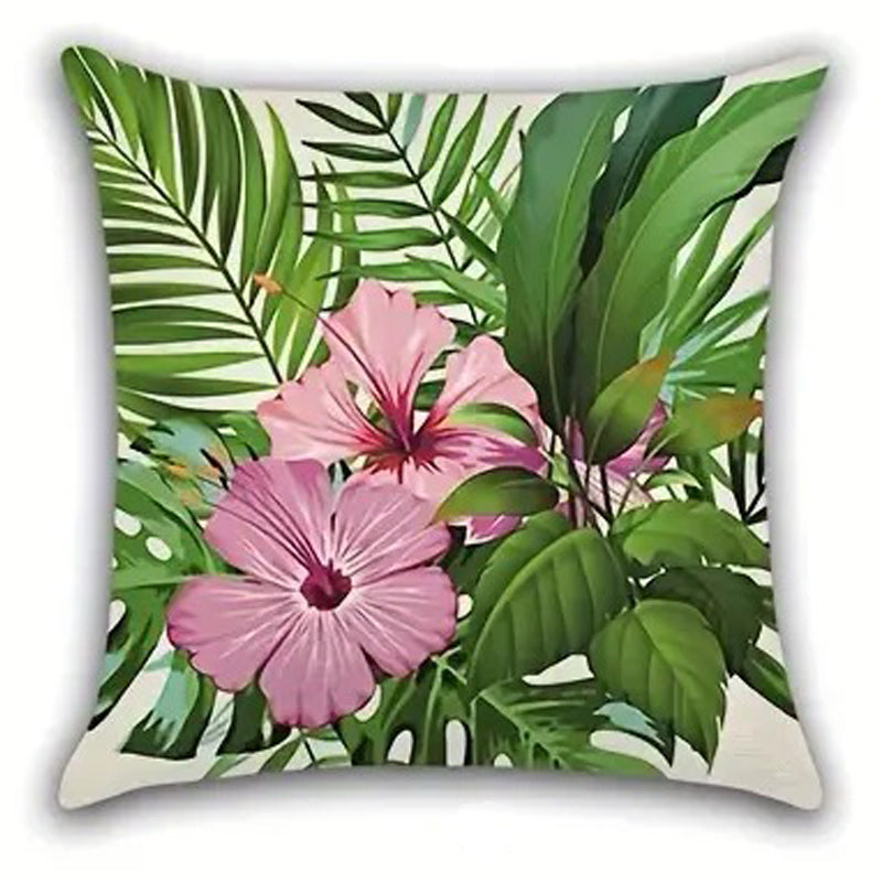 Decorative pillow cover featuring two pink hibiscus flowers positioned among green palm leaves on a light background.