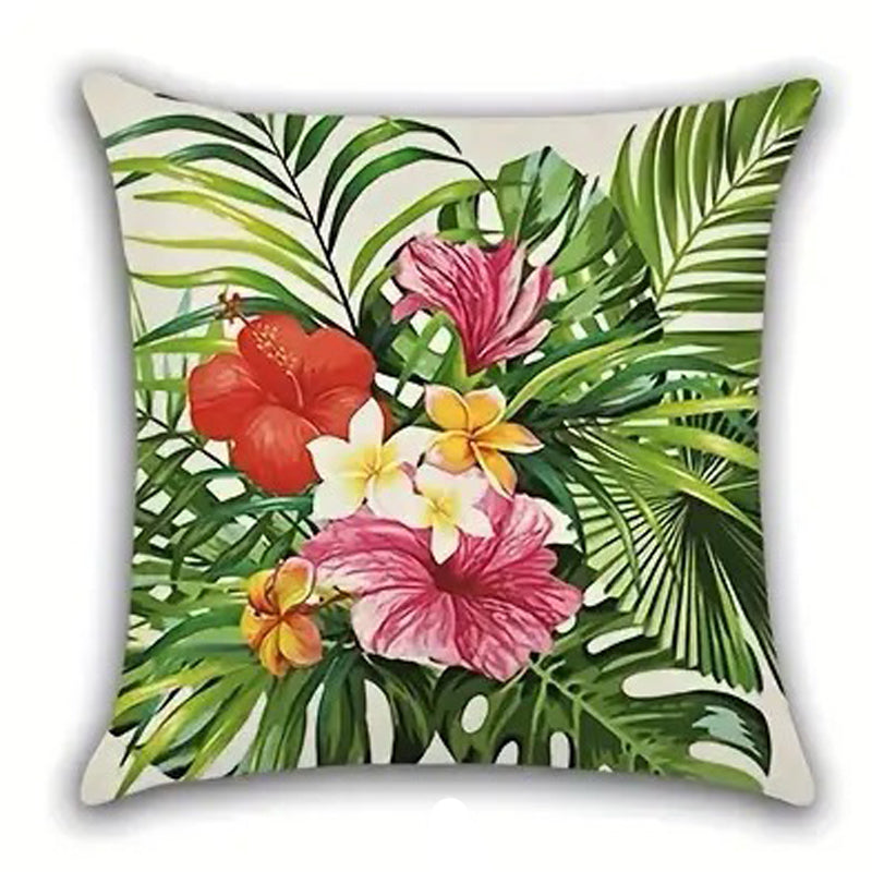Decorative pillow cover featuring a cluster of red, pink, and yellow hibiscus flowers layered over green palm leaves on a light background.
