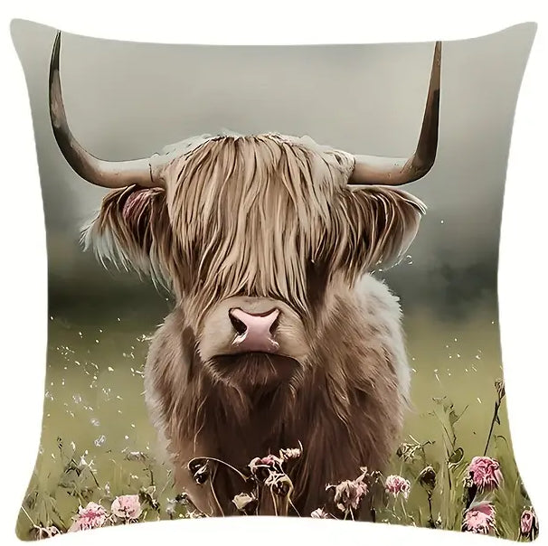 Square pillow cover featuring a Highland cow standing in a wildflower meadow with soft green background and pink blooms in the foreground.