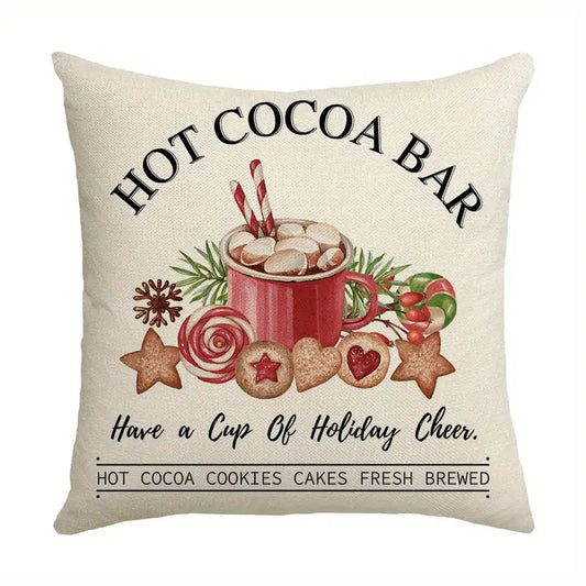 Pillow cover with hot cocoa bar text, a mug with marshmallows, cookies, and candy on a neutral background