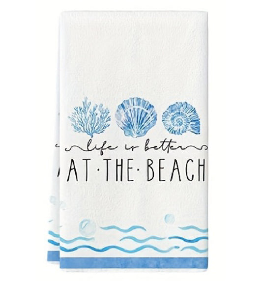 Towel with blue coral, shell, and wave designs on a white background