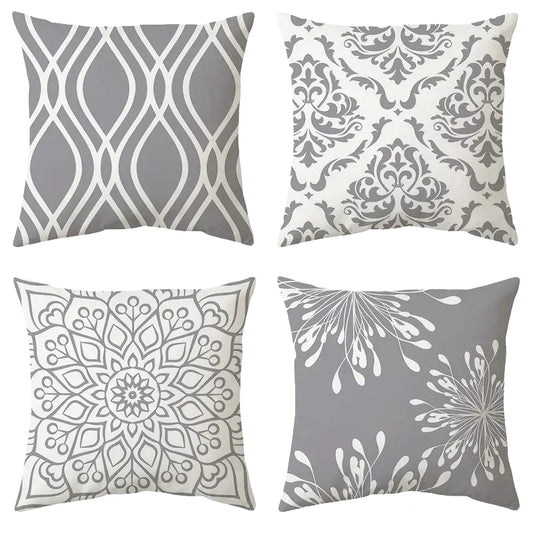 A set of four modern 18x18 inch pillow covers featuring diverse grey and white patterns, including an ogee wave, a classic damask, a detailed floral mandala, and a whimsical dandelion puff design for contemporary décor – Coastal Pillows Plus.