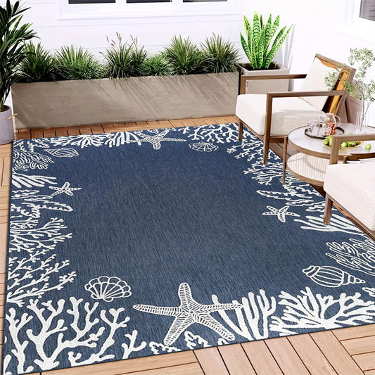 Coastal area rug featuring white starfish, coral, and seashell designs framing a deep navy blue center.