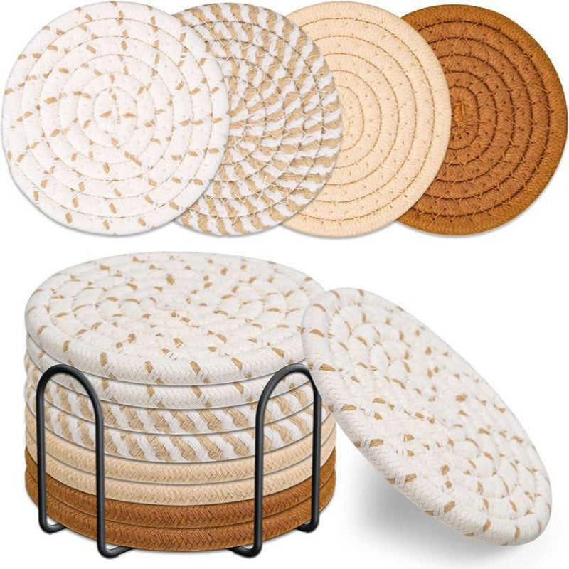 Round neutral woven coasters stacked in a black metal holder with mixed beige and brown tones.