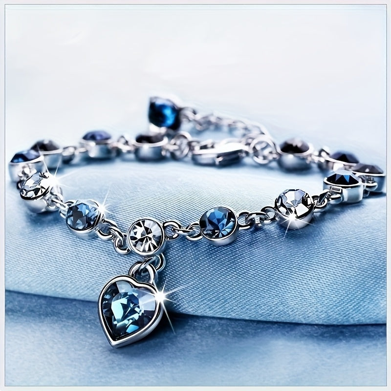 Elegant lake blue heart-shaped crystal bracelet with 925 silver plating on a soft blue textile background - Coastal Pillows Plus