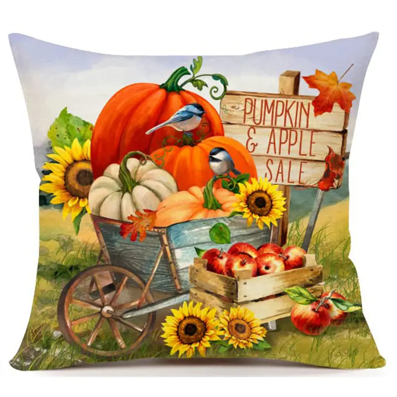 Pillow cover with pumpkins in wheelbarrow, apples in crates, sunflowers, birds, and Pumpkin & Apple Sale sign.