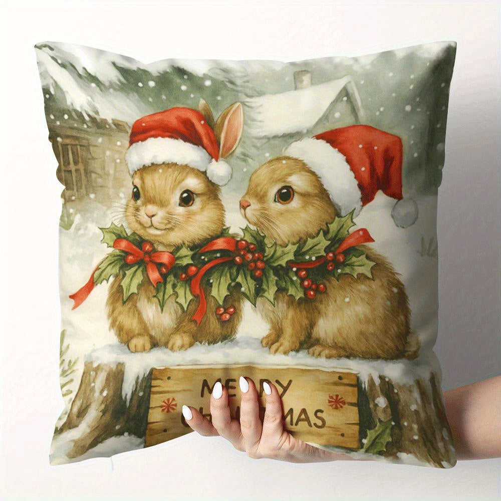Pillow cover with two rabbits wearing Santa hats and a Merry Christmas sign in a snowy winter scene