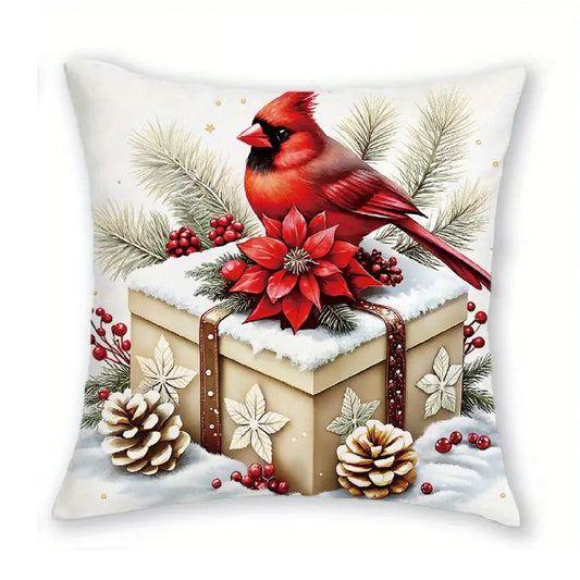Christmas pillow cover with a red cardinal sitting on a wrapped gift box surrounded by poinsettias and pine cones.