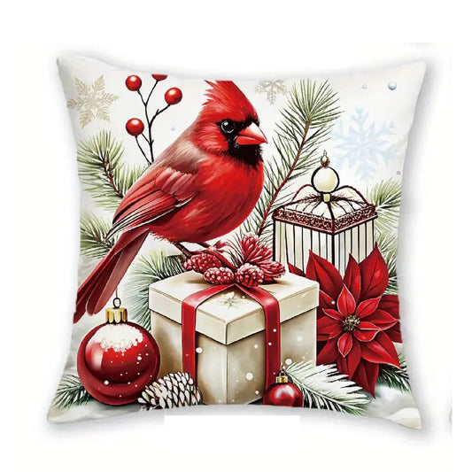 Christmas pillow cover featuring a red cardinal with a lantern, gift box, ornaments and poinsettia flowers.