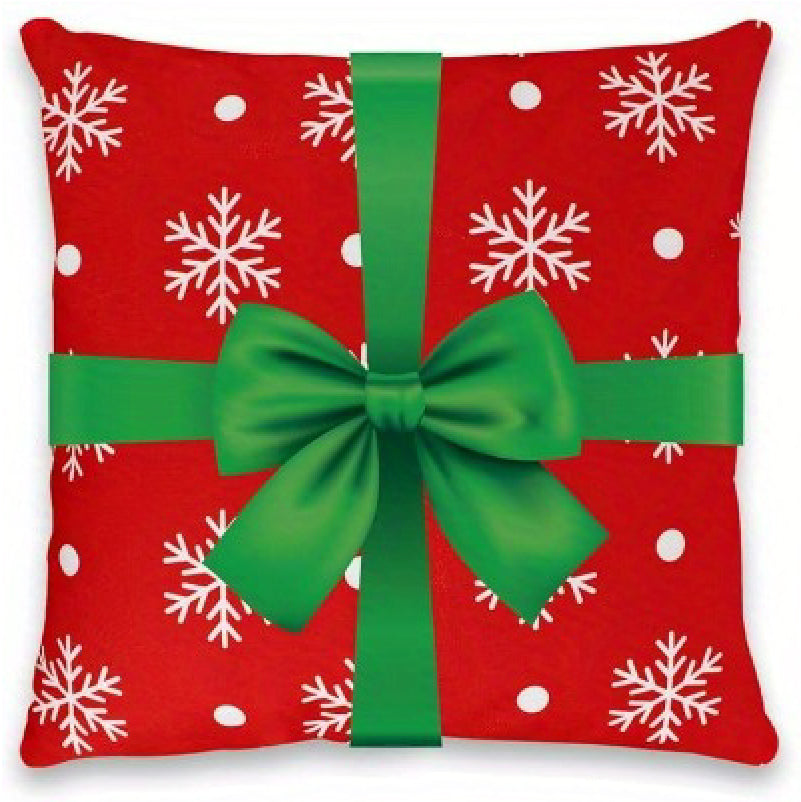 Red pillow cover with snowflakes and a green ribbon bow across the front