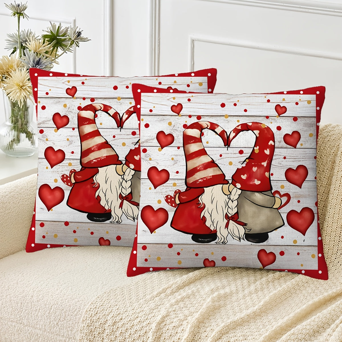 Playful 18x18 inch Valentine’s Day pillow cover with gnome couple forming a heart with their hats, red hearts and polka dots on white wood-grain background, styled on a sofa for seasonal décor – Coastal Pillows Plus.