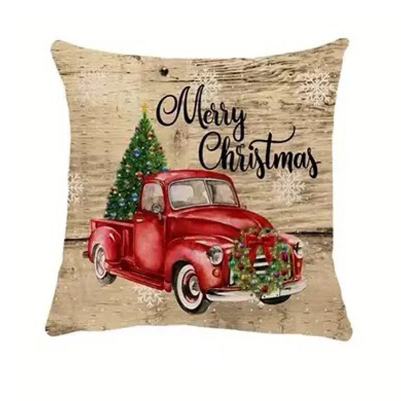 Christmas pillow cover featuring a vintage red truck carrying a Christmas tree on a rustic wood background.