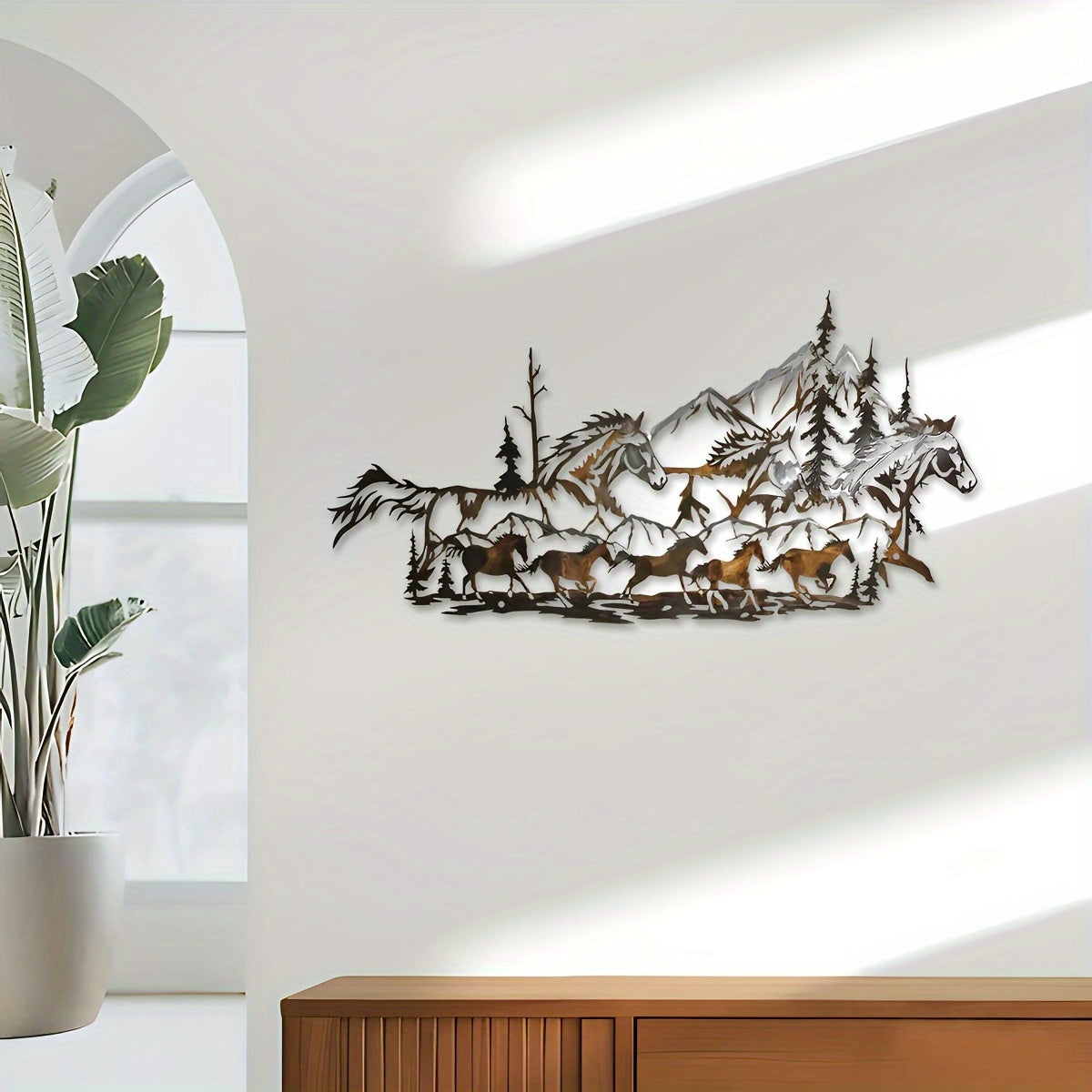 A rustic iron wall art piece featuring a herd of running horses against a mountain landscape. - Coastal Pillows Plus