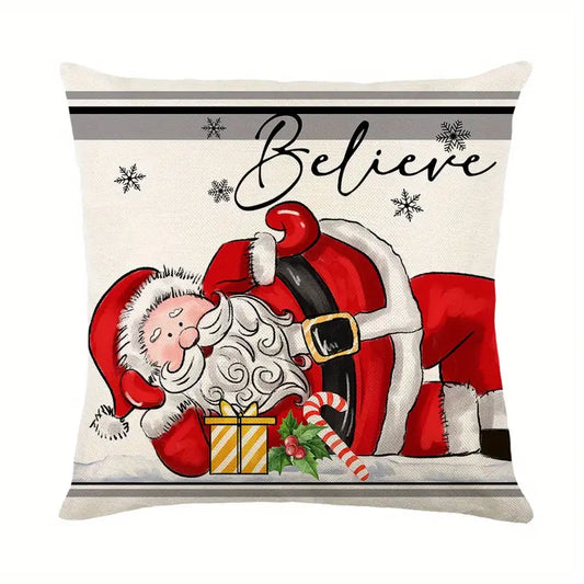 Decorative pillow cover featuring a whimsical illustration of Santa Claus resting in the snow with a gift and candy cane under the word "Believe" for holiday decor - 18x18.