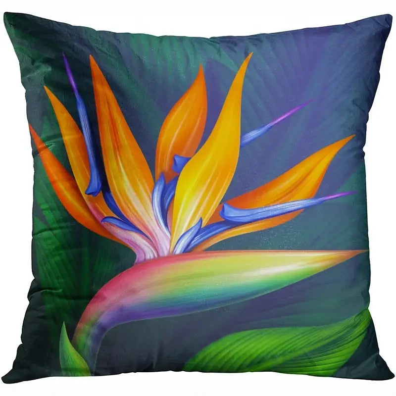 Decorative pillow cover featuring a bird of paradise flower in orange, yellow, blue, and green tones on a dark green background.